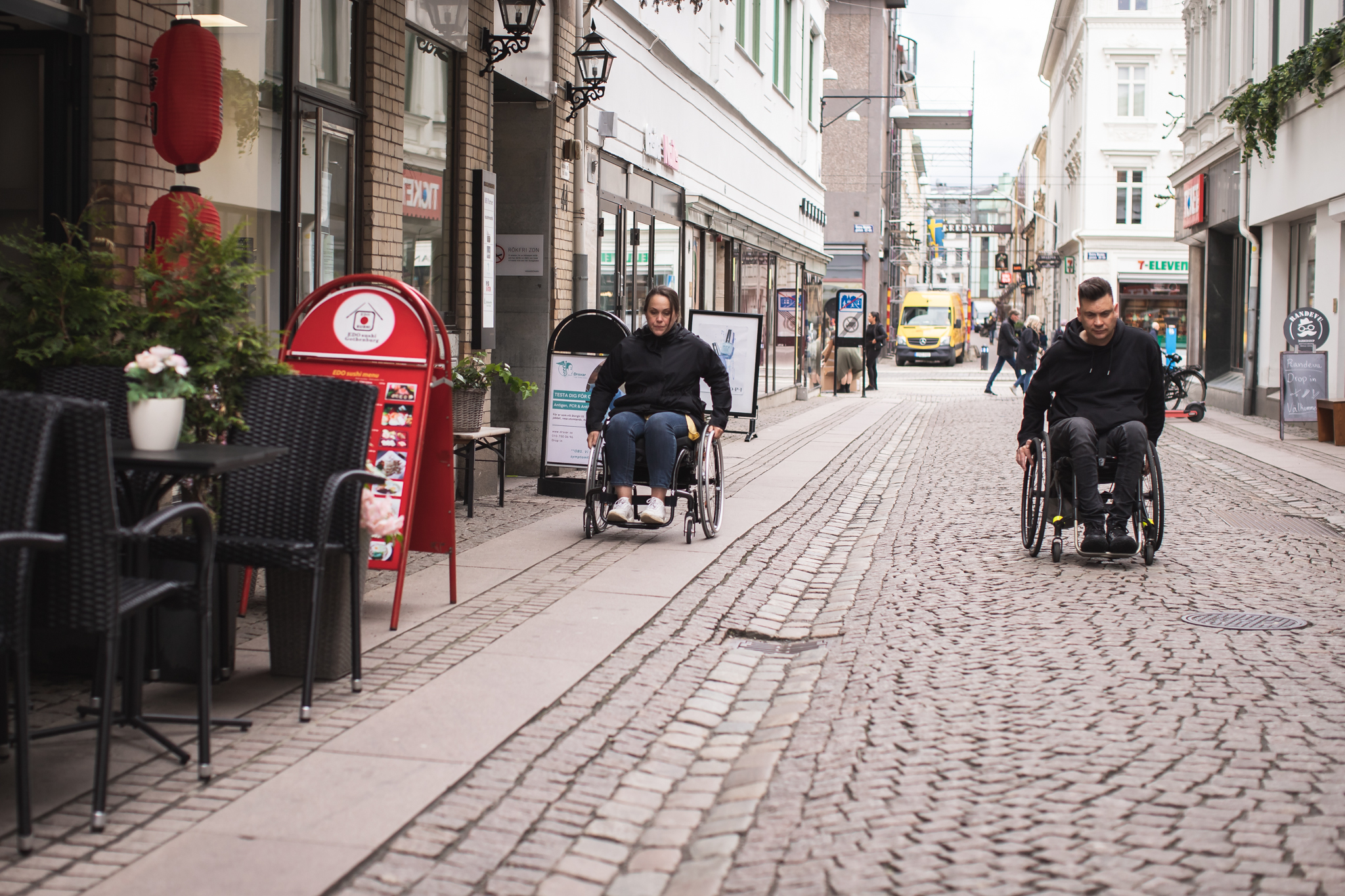 Annasara Perslow och Anders Westgerd, båda kör rullstol på gatustensbelagd gata