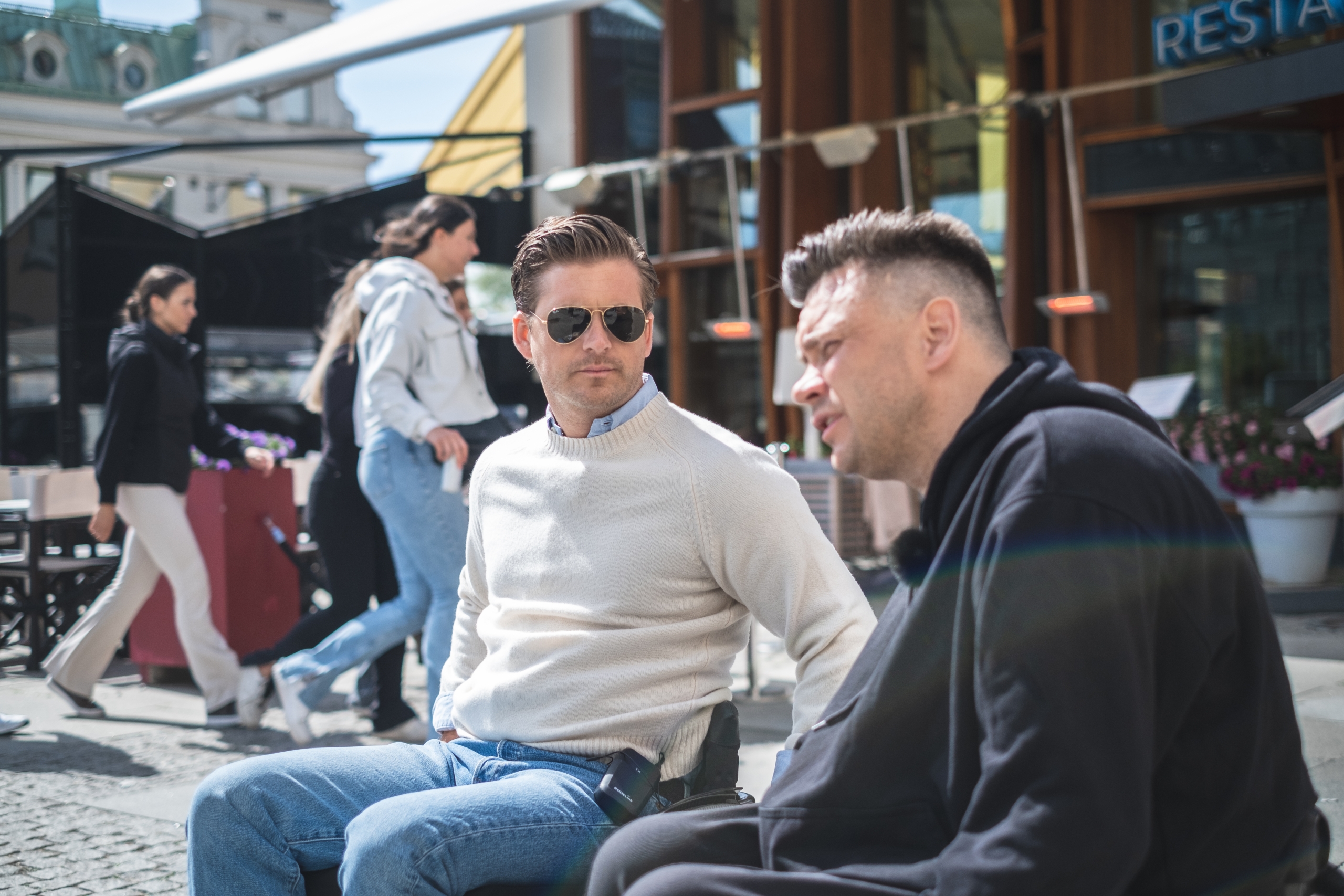 Hampus Magnusson och Anders Westgerd, båda i rullstol, sitter på torg och pratar.