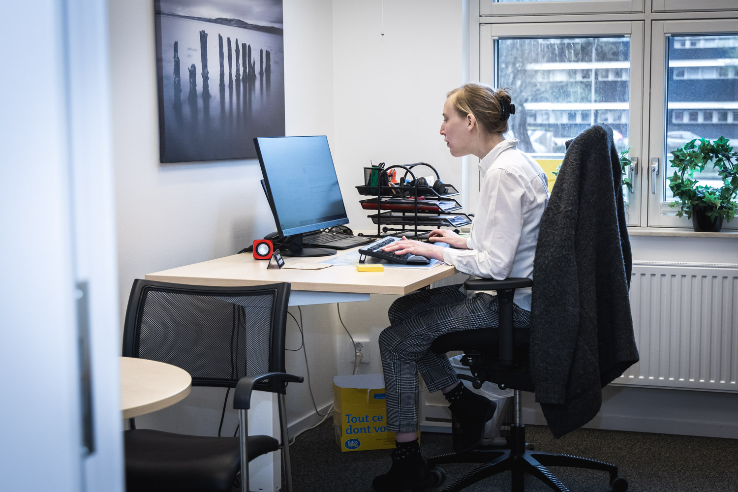 Maria inne på sitt kontorsrum, hon sitter vid datorn och tittar på skärmen.