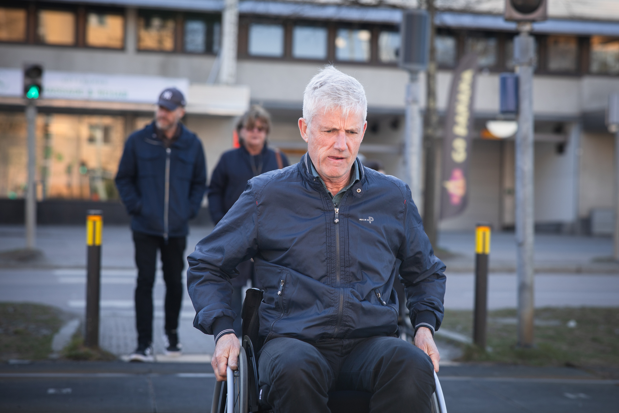 Man i rullstol, han ser koncentrerad ut med tungan utåt mungipan.