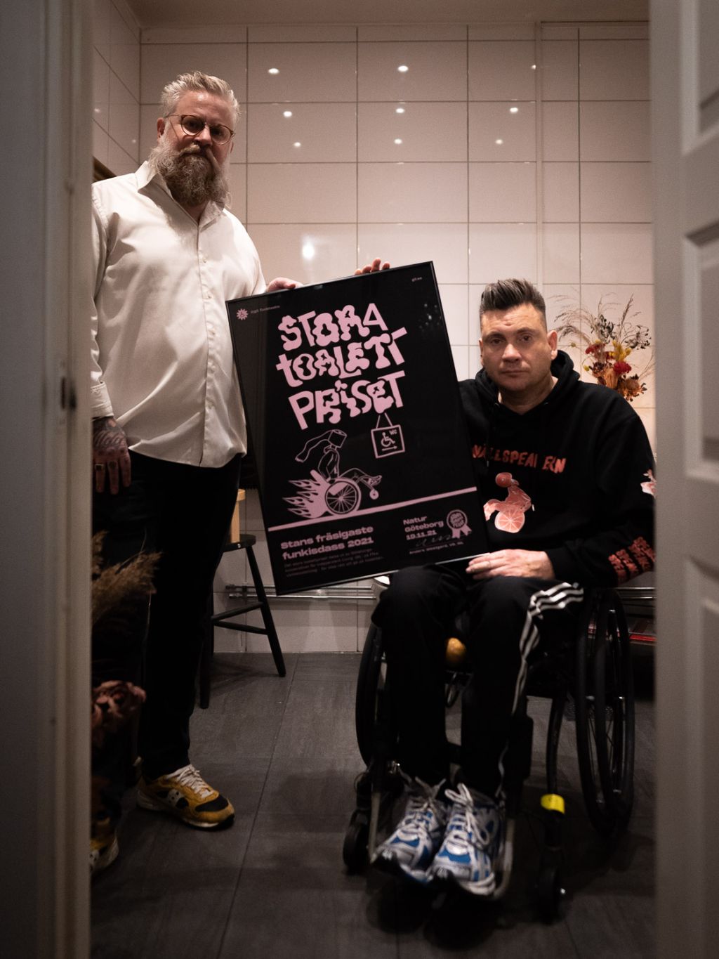 Peter Orrmyr och Anders Westgerd håller tavla på toalett
